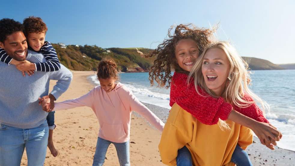 Happy family walking on beach